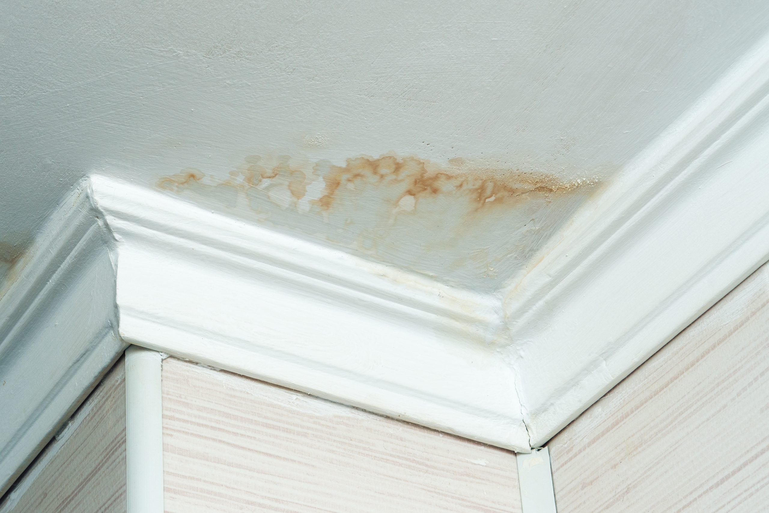 Neighbors have a water leak, water-damaged ceiling, close-up of a stain on the ceiling.
